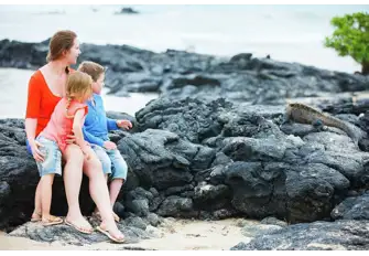 Children will be fascinated by wildlife unique to these islands, like this marine iguana scrambling over the lava