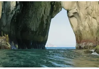 Cerro Brujo, also known as Witch Hill, has a natural stone arch, through which we can see Kicker Rock