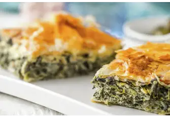 The ubiquitous spanakopita sandwiches spinach and feta cheese between layers of filo pastry