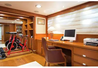 Behind a wardrobe door in the owner's office, there are weights and an exercise bike that swivels out