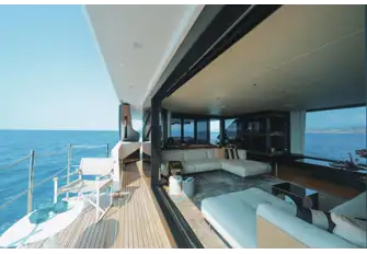 A sliding glass wall opens onto a folding balcony to starboard