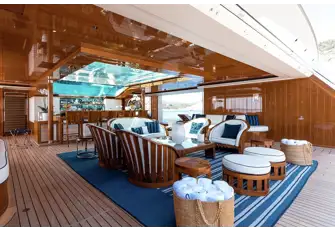 The beach club on the 96.6m (316.8ft) Feadship FAITH, for charter with Burgess, opens on three sides and sits beneath a glass-bottomed pool