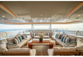 Looking across the main deck aft from the shaded lounge area to the sun lounge beyond with glass bulwark to protect the views