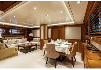 Lounge and formal dining in the main saloon, with natural light through large hull ports