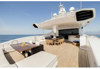 The main deck aft has built-in sun lounge seating and open-air dining