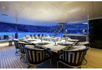Open-air dining on the upper deck with a sun lounge aft