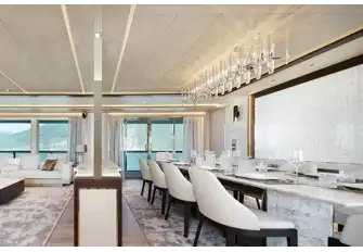The dining room, forward in the main saloon, benefits from excellent natural light through full-height windows and glazed bulwark cut-outs