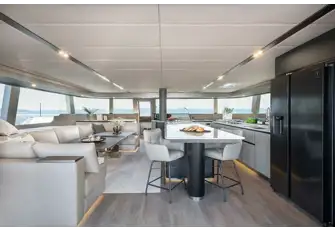 Looking forward in the main saloon, with the lounge to port and galley to starboard. The door forward leads to a foredeck sun lounge