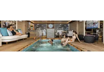 Looking from the swim platform across the beach club pool with bar and lounge