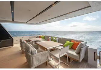 Open-air dining on the main deck aft, with steps either side leading down to the swim platform and tender garage