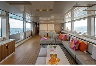 Looking forward in the beach club-style saloon with the sliding glass door and balcony to port