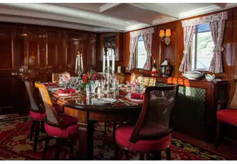 Dine in the mahogany panelled dining room, the beating heart of the yacht