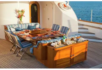 Aft of the main saloon is a dining area partially shaded by the aft flybridge