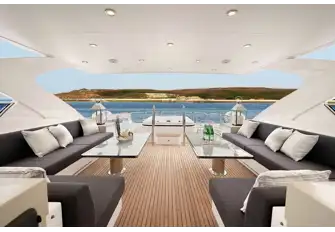 Looking aft on the sun deck past the BBQ and bar to port, lounge seating, jacuzzi and deck crane