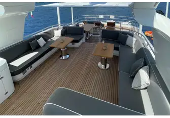 Looking aft on the flybridge, across the large lounge with informal open-air dining, and a bar and sun lounge on the lower level