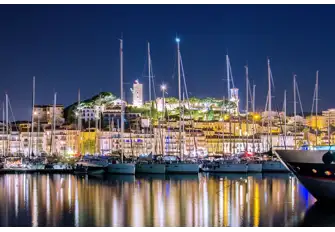 Cannes Vieux Port packed with yachts and overlooked by Notre-Dame de l'Esperance