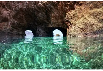 Dive or snorkel to explore the Dragonisi Caves in Mykonos