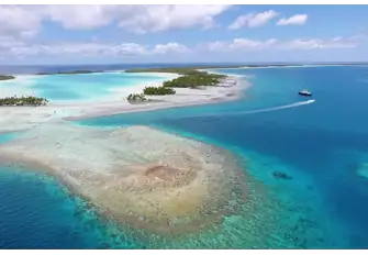The 44.2m sailing catamaran HEMISPHERE anchored off a blue lagoon in the Tuamotus